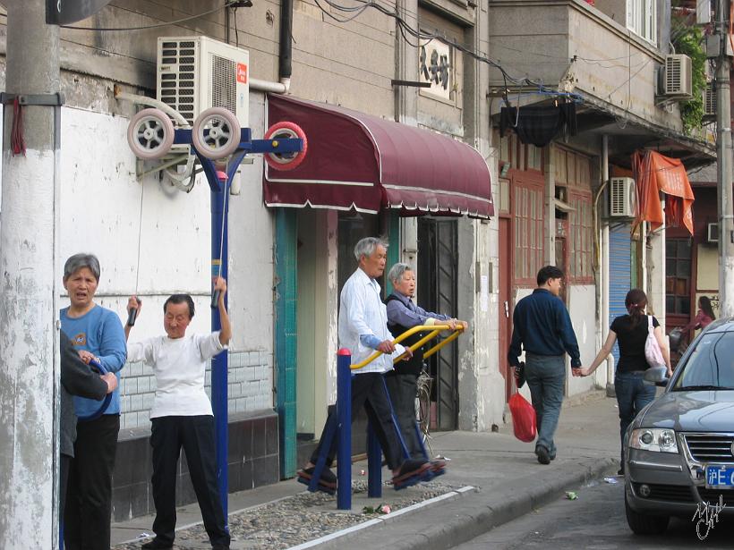 0604Sgh_Shanghai 064.jpg - Des personnes âgées faisant de la gym sur des appareils en libre service dans les rues de Shanghai. À l'exception de 55 ethnies minoritaires, les familles n'ont droit qu'à 1 enfant, ou 2 pour les familles rurales ayant eu 1 fille en premier. Certaines familles privilégiées paient des amendes d'env. 2000 Eur par enfant supplémentaire.